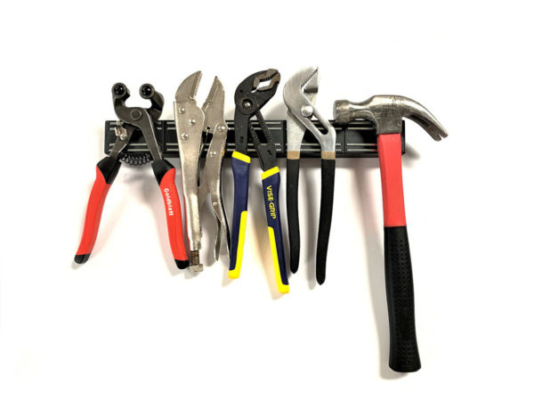 Wrenches and hammer being held on magnetic strip holder